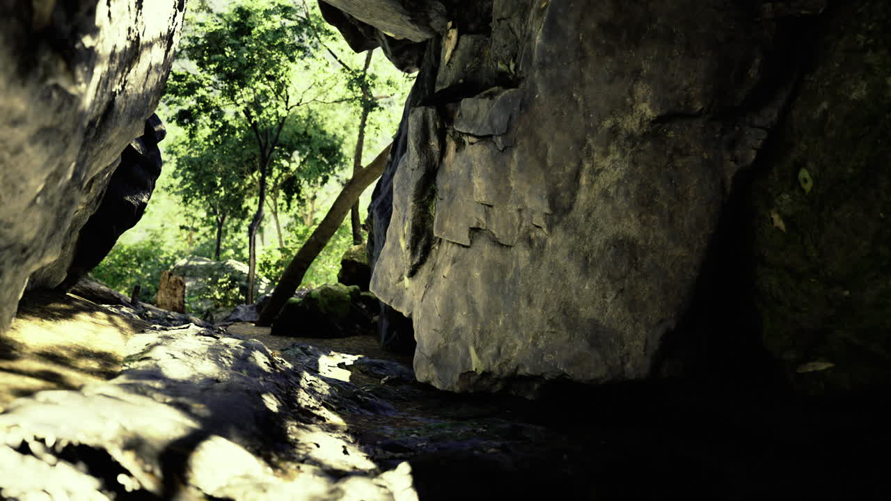 Exploring a rocky cave entrance surrounded by lush greenery in daylight