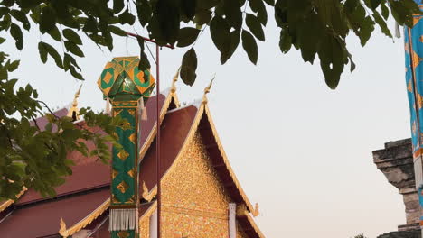 static shot of wat chedi luang's golden roof, moving lantern, and a bird in the sky, chiang mai - thailand
