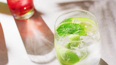 Close-up-of-drinks-with-orange,-raspberry-and-lemon-over-shadow