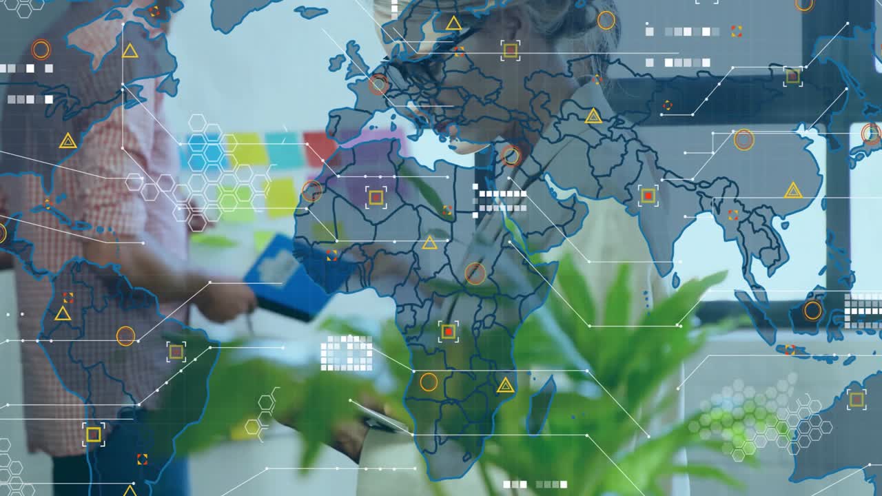 Mid adult woman tapping tablet and updating animated map overlay during business analytics meeting