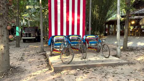 pedicabs near large american flag in thailand