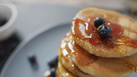 Video-of-pancakes-on-plate-seen-from-above-on-wooden-background