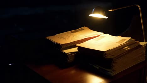 stack of old documents under a lamp