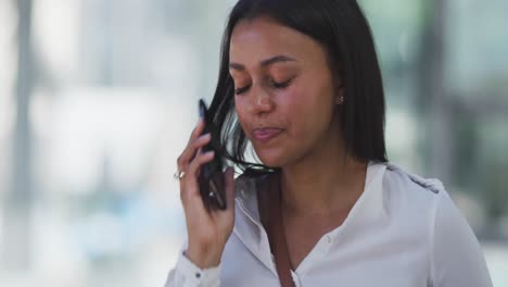 mujer afroamericana hablando en un teléfono inteligente en la calle