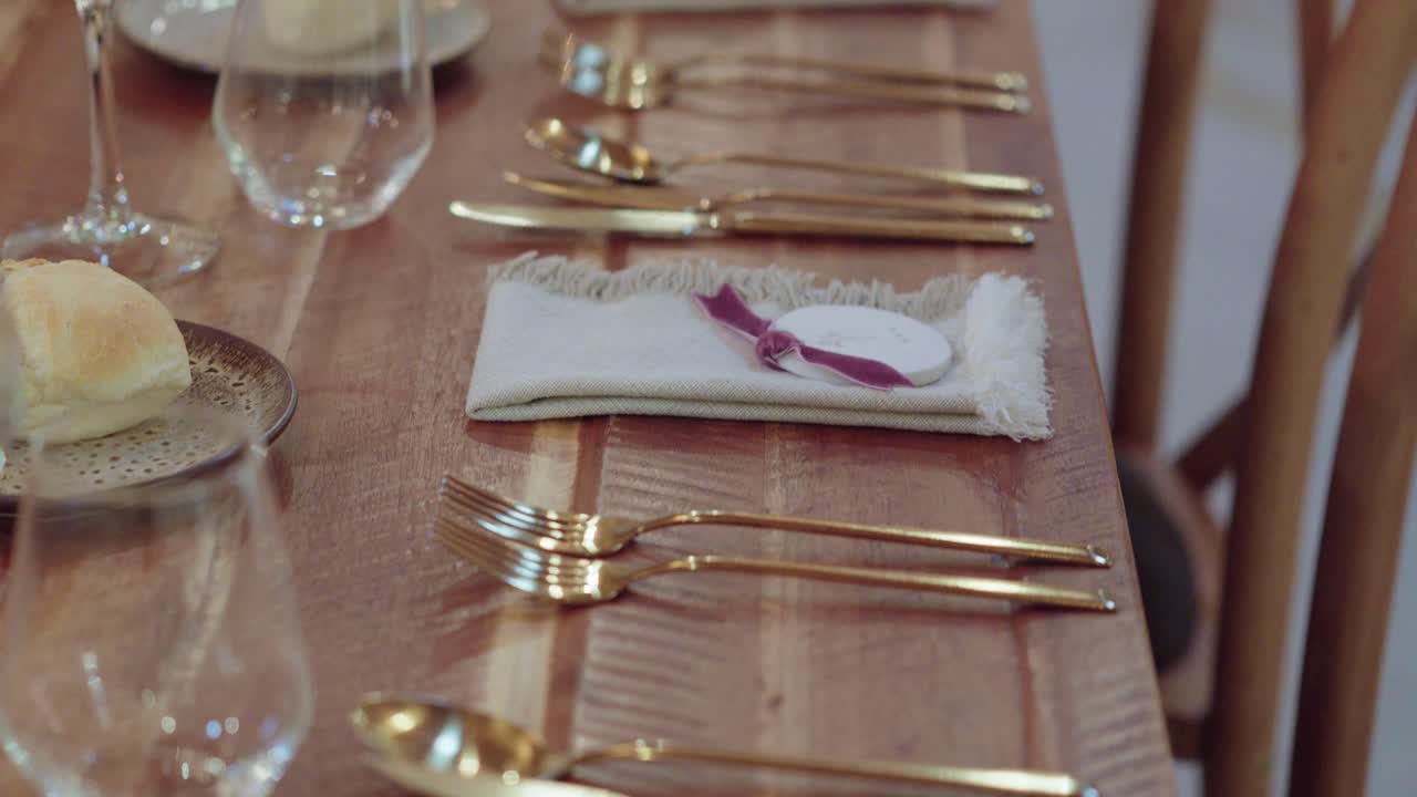 Close-up of golden forks and spoons arranged on wooden dining table
