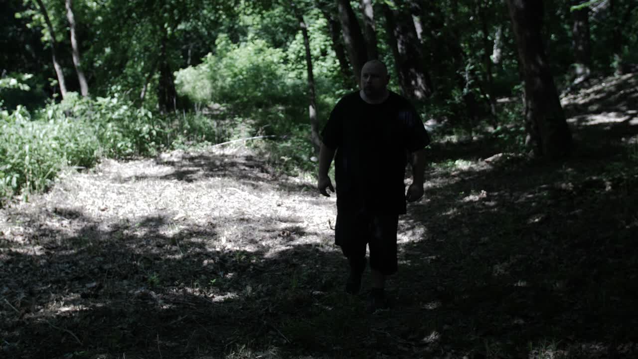 Un uomo che cammina tra gli alberi del bosco