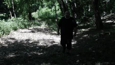 a man walking through forest trees