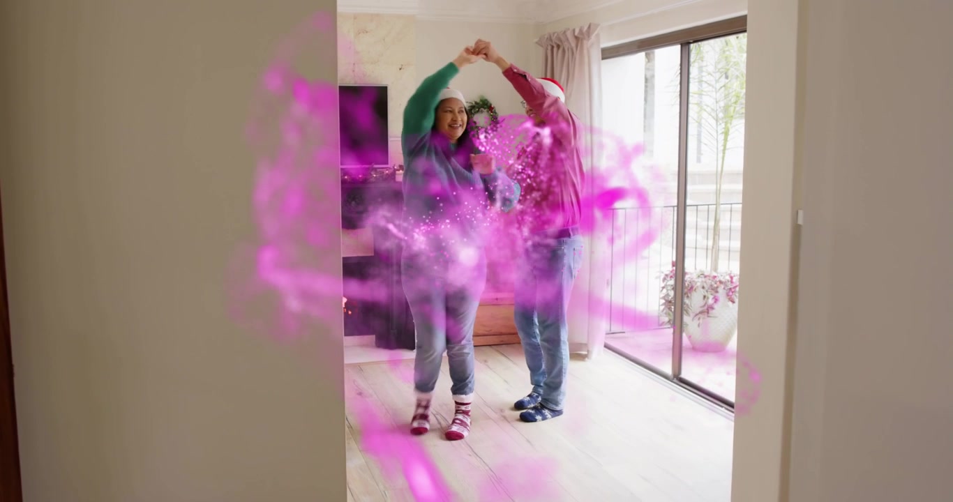 Mature adult woman and senior man dancing under pink mist materializing for holiday marketing