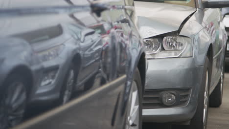 detail of car with bodywork panels damaged in motor vehicle accident parked in garage repair shop