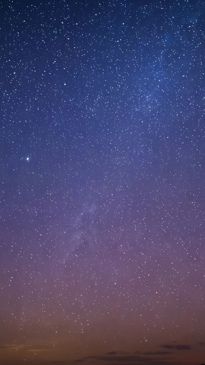 Vertical video: Timelapse camera filming stars above low horizon showing Milky band and bright star