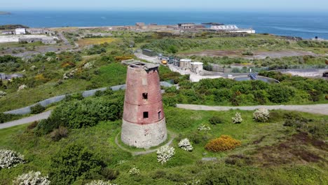 amlwch port red brick disused abandoned windmill aerial view north anglesey wales slow wide orbit left