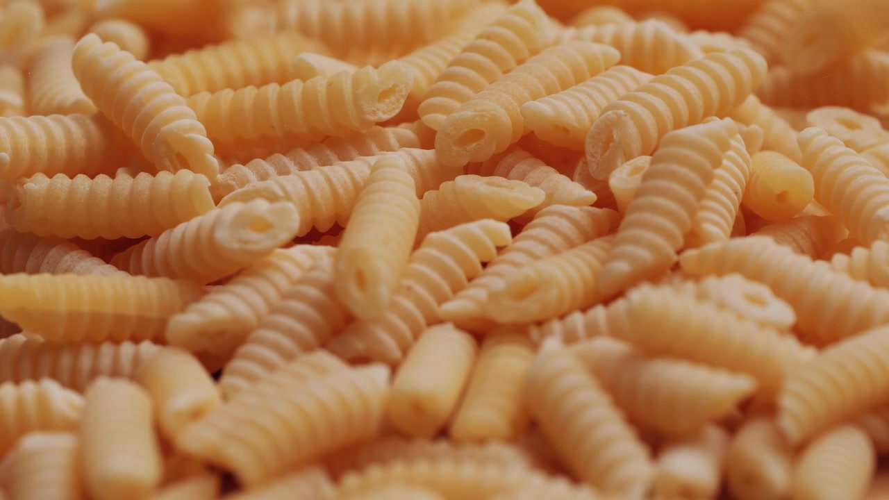 Cavatappi crudi che cadono e si accumulano