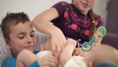 hermanos jugando con el bebé. acercamiento de tres niños se divierten en casa