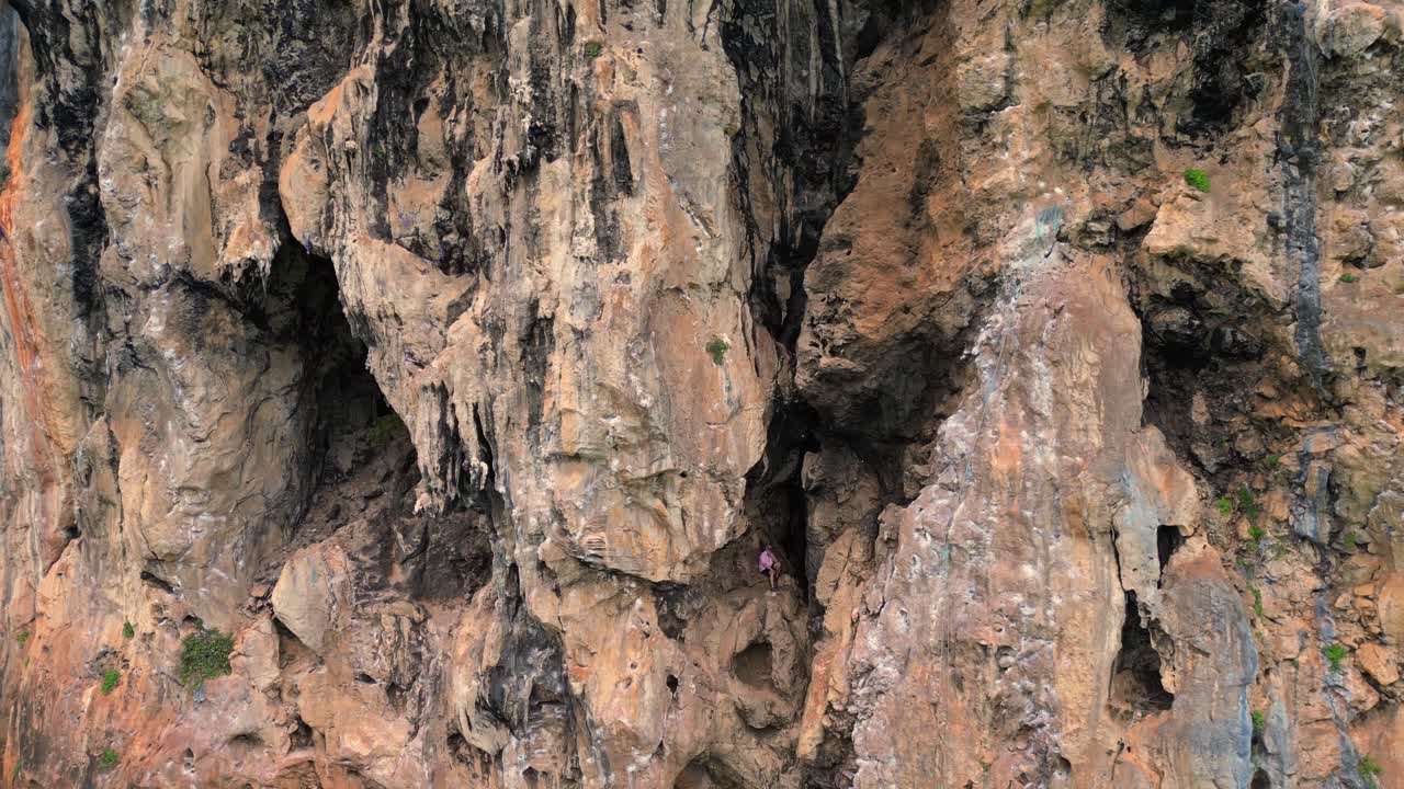 Rock climber resting during a difficult climb on Rai Leh beach cliff in Thailand. speed ramp hyper motion time lapse