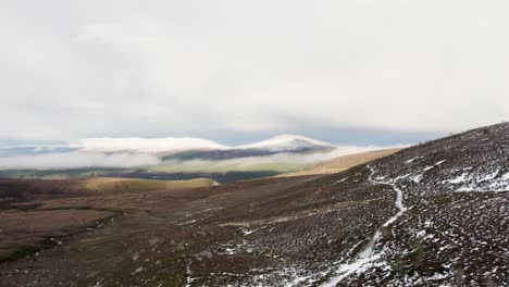 在蘇格蘭的cairngorms國家公園拍攝的冬天無人機拍攝的片段, 雪<unk>,山脈和雲端望向aviemore和glen more, 有一條冰<unk>的路徑.