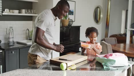 Video-of-african-american-father-and-daughter-preparing-breakfast