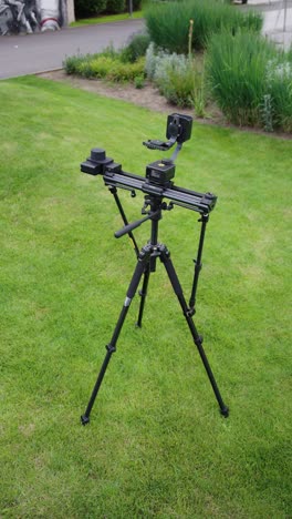 High-angle-view-of-electronic-slider-tripod-on-green-grass-lawn,-Czechia