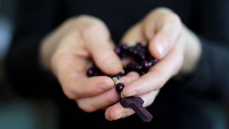 woman-praying-with-hands-together-with-cross-on-black-background-with-people-stock-video