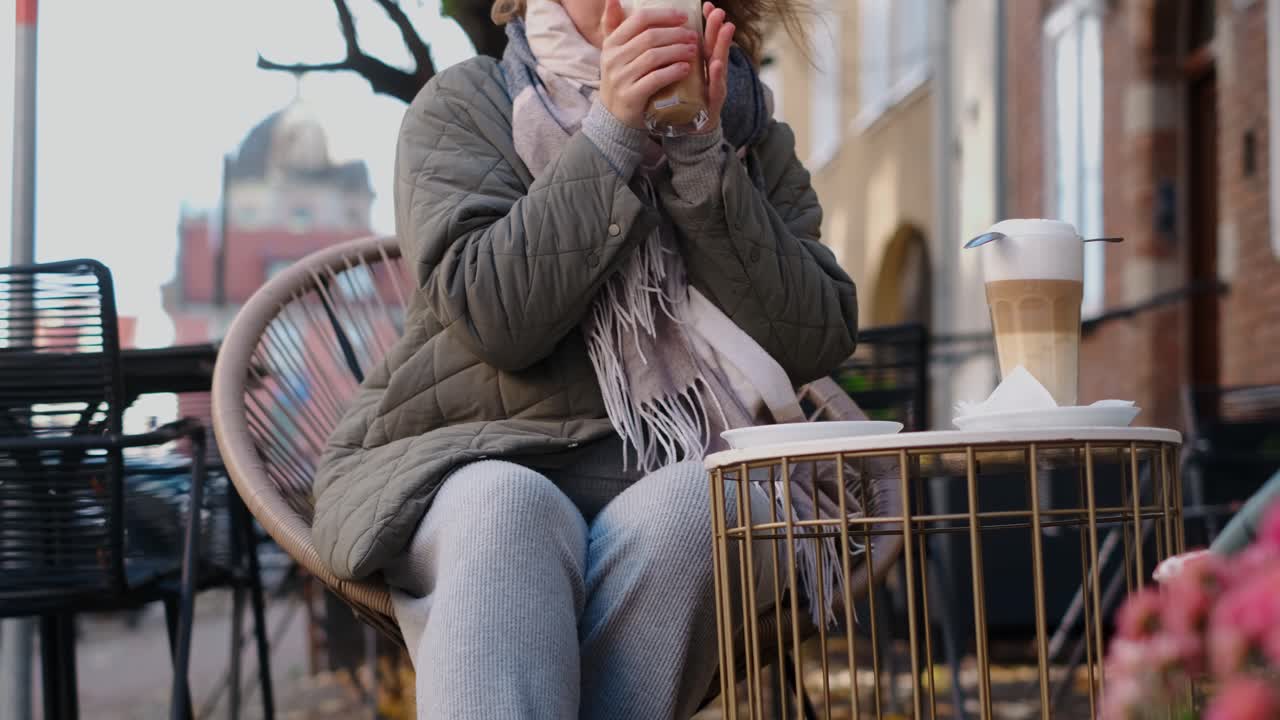 Woman enjoying a latte in a cozy outdoor cafe