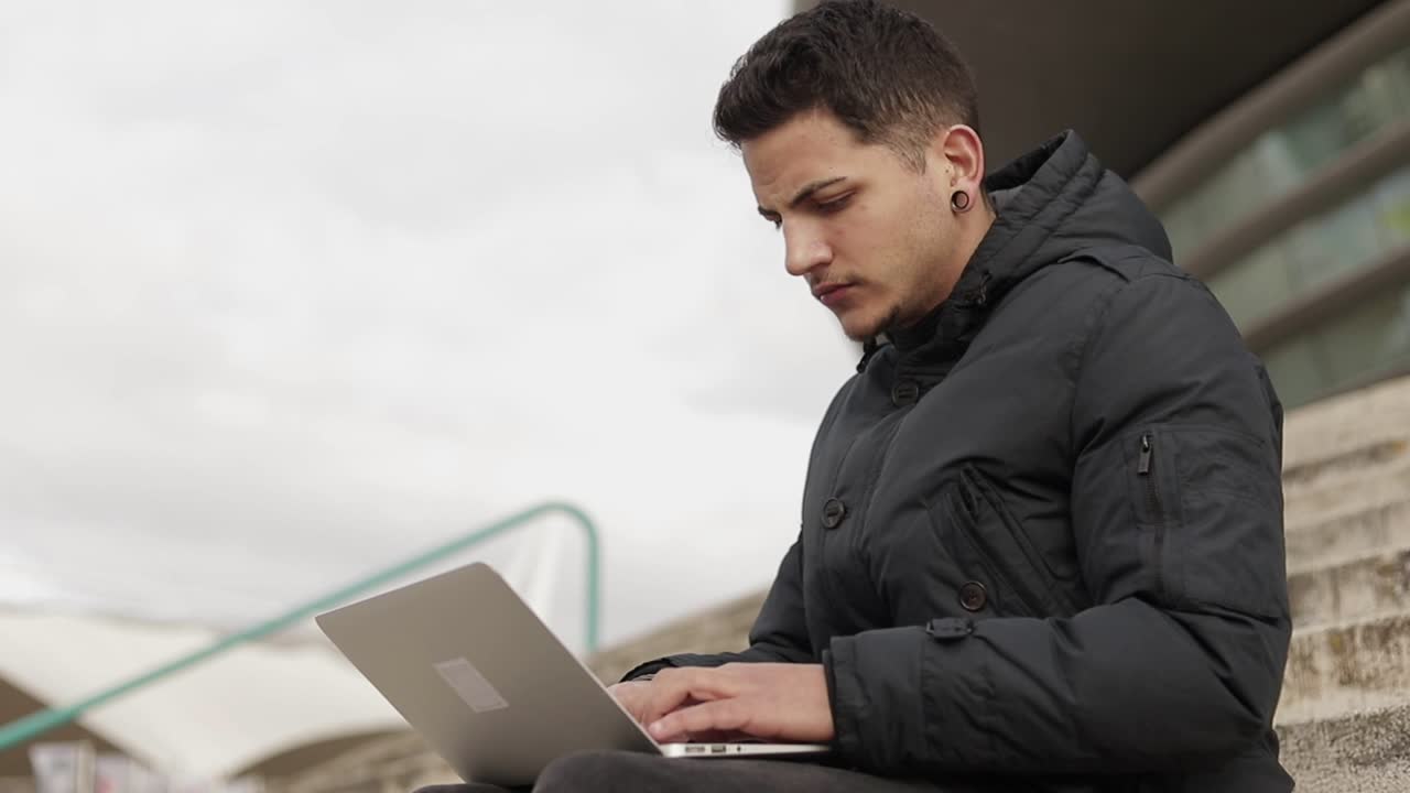 disparo en cámara lenta de un joven escribiendo en una computadora portátil