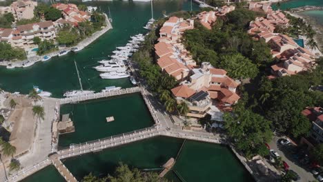 drone footage of dolphin discovery and the marina in puerto aventuras, featuring turquoise enclosures, red-roof buildings, and oceanfront views