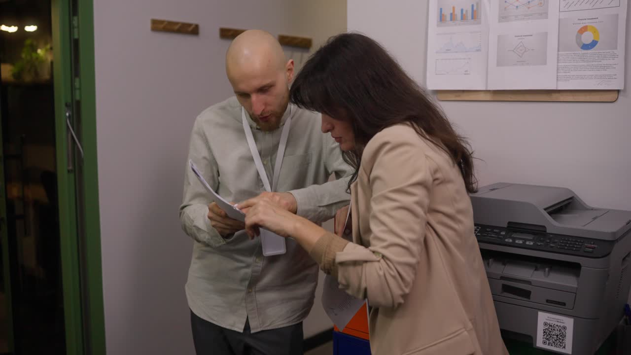 Two colleagues reviewing documents in office
