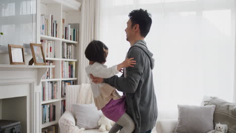 cute-little-asian-girl-jumping-into-fathers-arms-happy-dad-gently-catching-his-daughter-enjoying-playful-game-with-child-at-home-4k