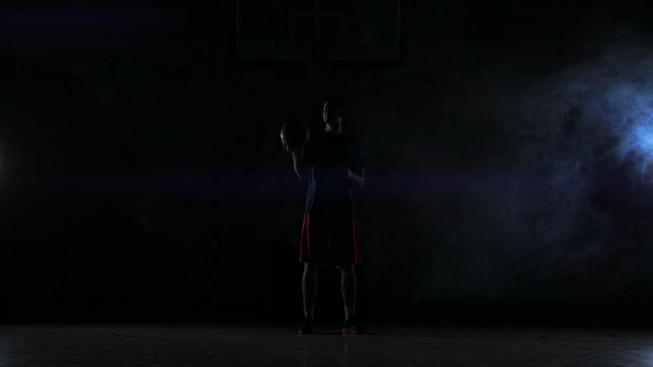 jugador de baloncesto callejero girando la pelota mientras la cámara lo rodea