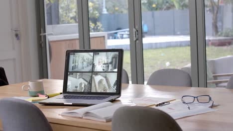 portátil en la mesa de comedor que muestra cuatro vistas de cámaras de seguridad en el hogar, cámara lenta