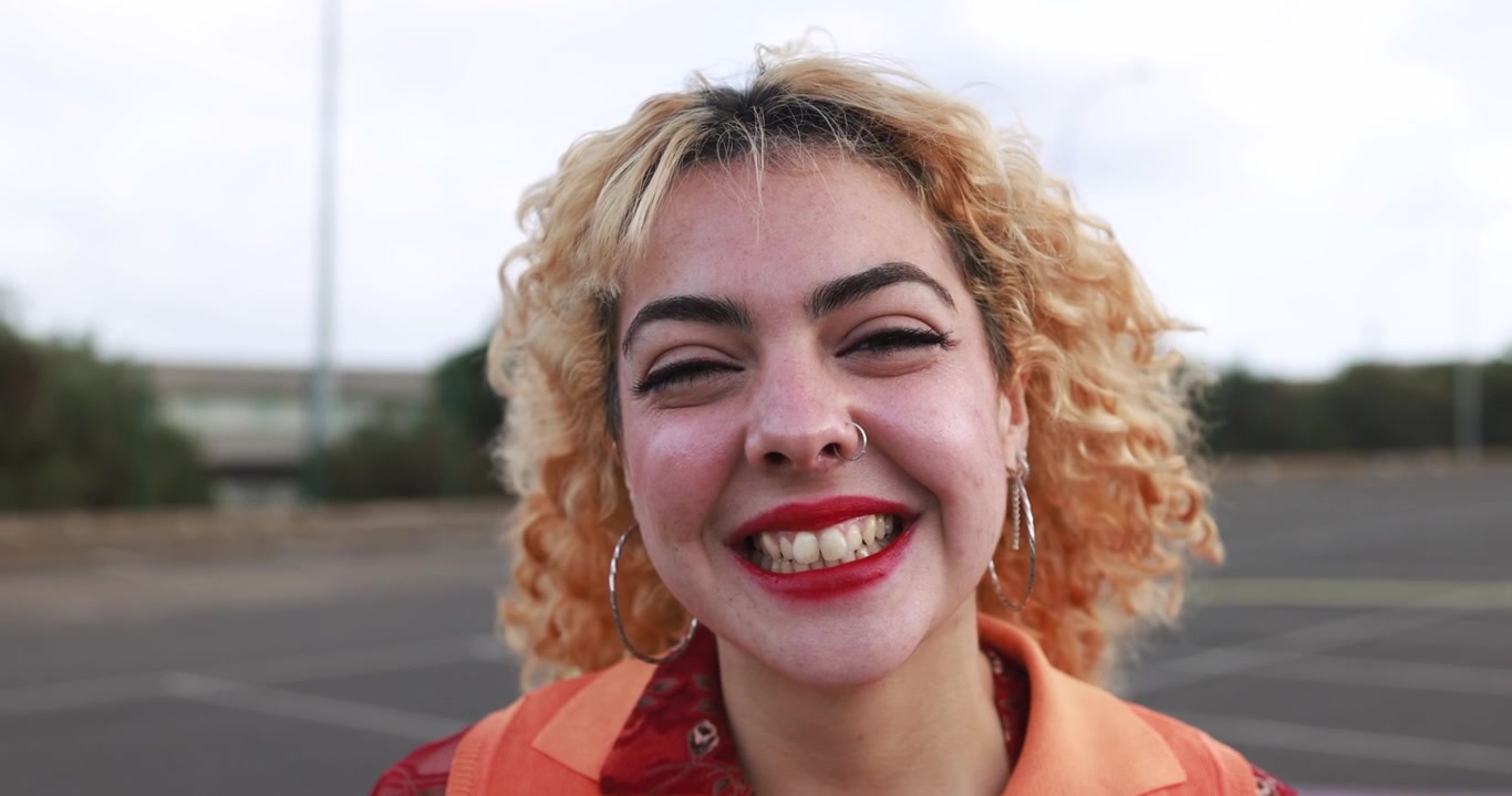 Primer plano de retrato de una mujer joven feliz sonriendo a la cámara