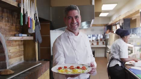 caucasian chef showing his dish