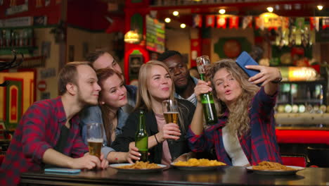 Friends-take-pictures-on-the-phone-at-the-bar-make-a-shared-photo-on-the-phone.-Party-with-friends-at-the-bar-with-beer.