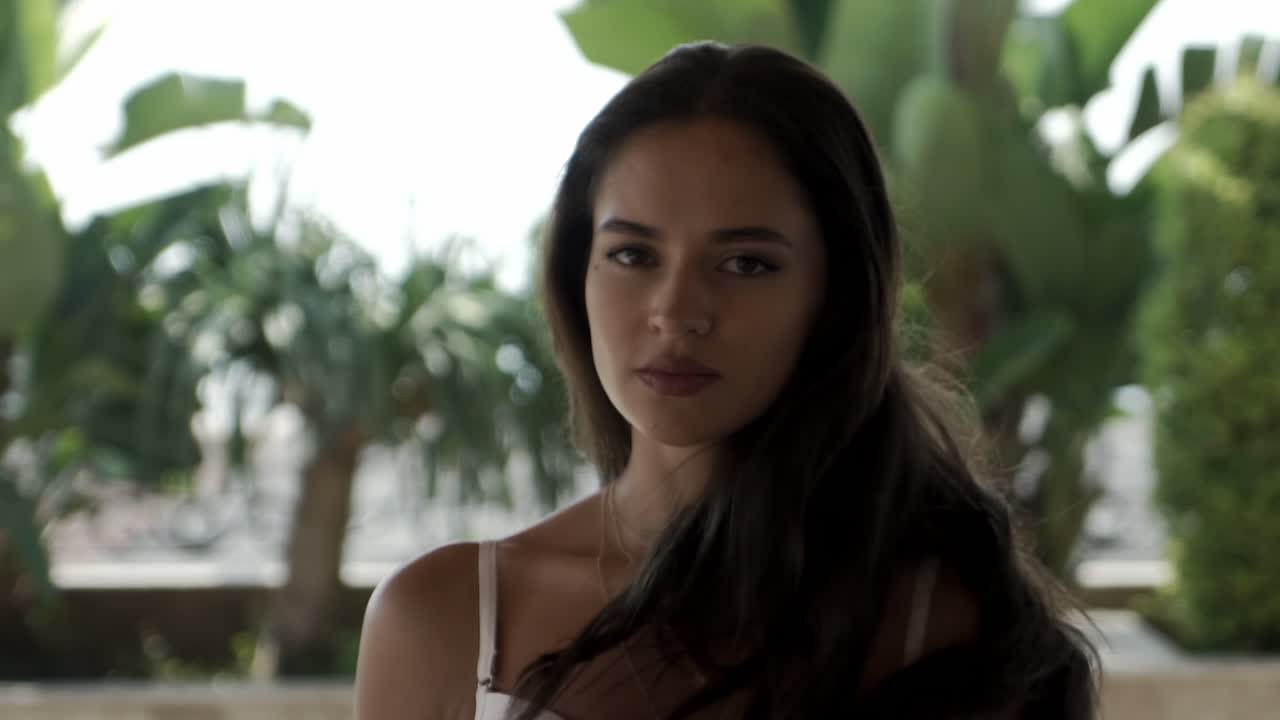 Beautiful girl in a white bathing suit posing on the camera in slow motion