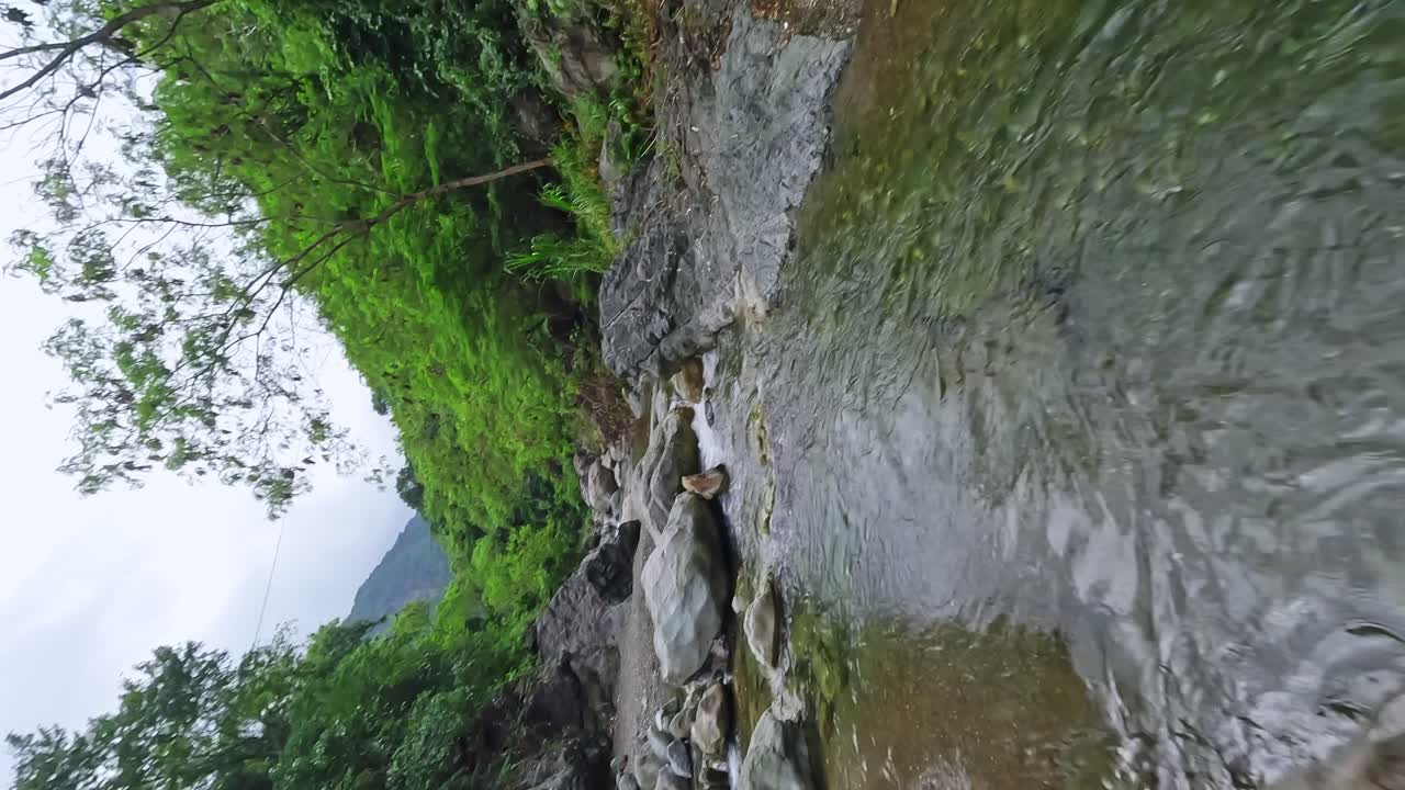 Vertical flight over rocky river floating in Wilderness of Dominican Republic , Bani, Peravia