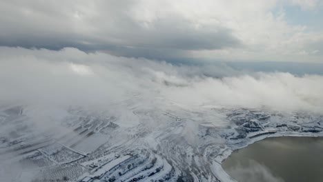 tirando de la vista aérea del lago ram cubierto de nieve con nubes densas, israel