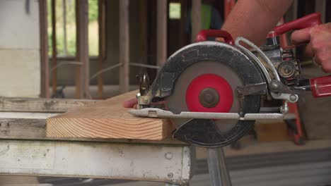 closeup of construction worker cutting with circular saw