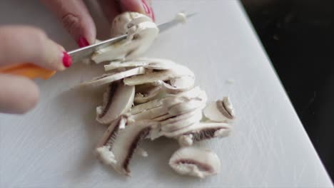 slicing mushrooms on a chopping board close up