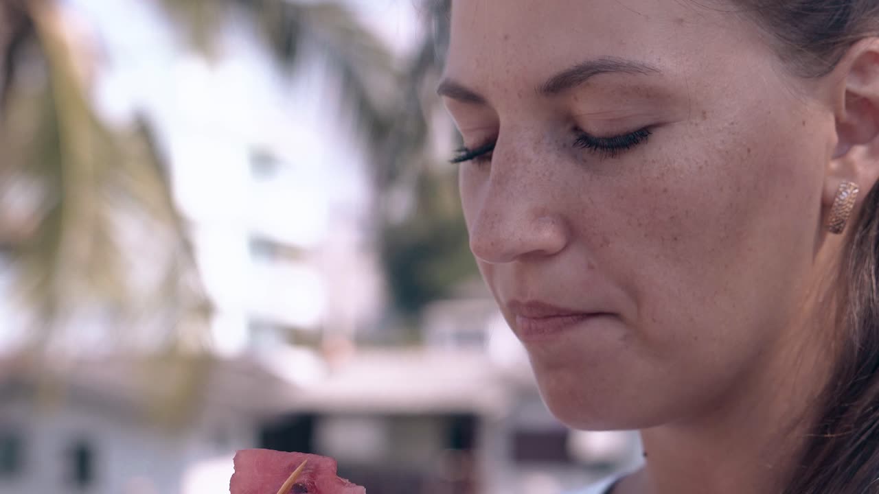 una dama maravillosa con pendientes de oro come una rebanada de sandía