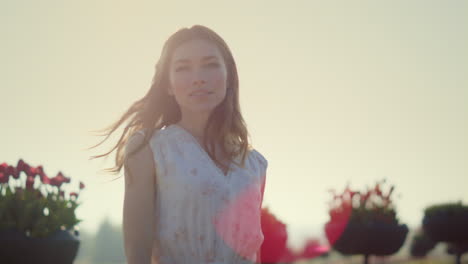 Mujer-Relajada-Con-El-Pelo-Ondulado-Caminando-En-El-Parque-De-Verano-Bajo-El-Reflejo-Del-Sol-Afuera.