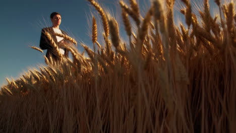 man in a suit in a wheat field at sunset
