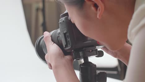 close up of asian female photographer taking photos of women's shoes in home studio