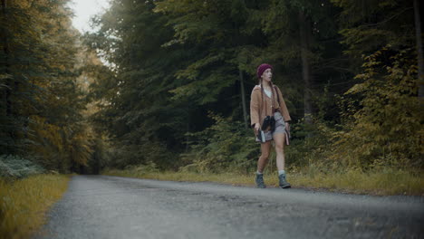 explorer with binoculars in her neck walking on road