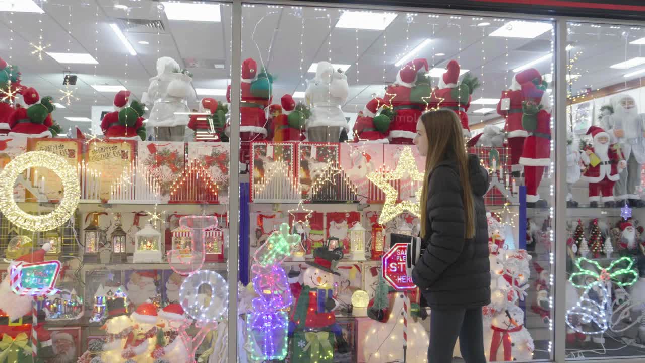 ventana de compras como un joven adolescente ve las ofrendas de navidad a la venta