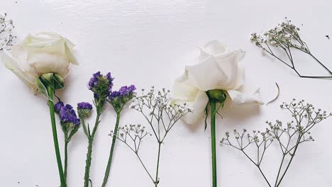 delicado arreglo de rosas blancas y flores púrpuras
