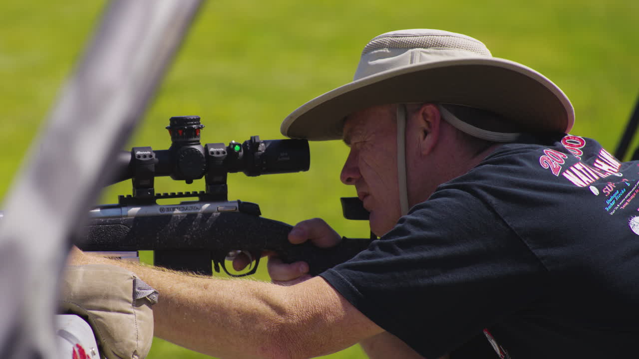 primer plano de un tirador profesional apuntando y disparando un rifle hacia el objetivo en el partido de la serie de rifles de precisión en leach, oklahoma