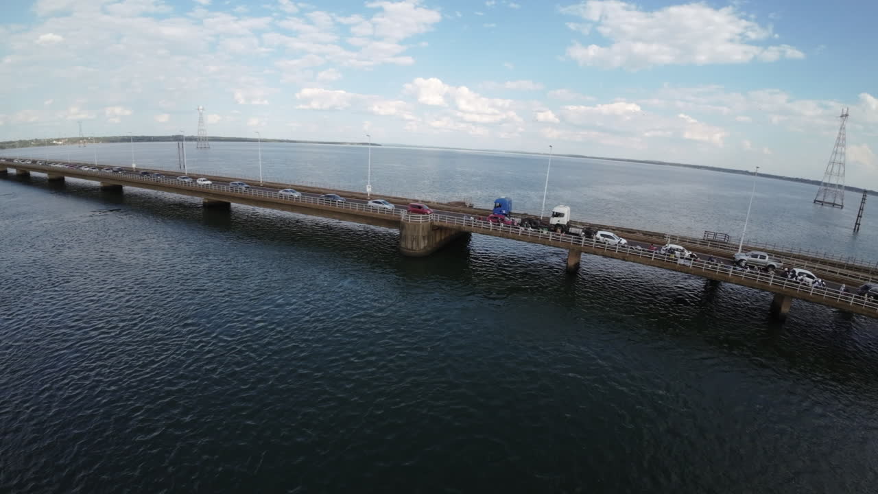 Aerial drone view of binational railway bridge with vehicles and trucks over Parana River