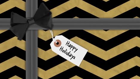 animation of happy holidays text on tag over christmas present with black ribbon