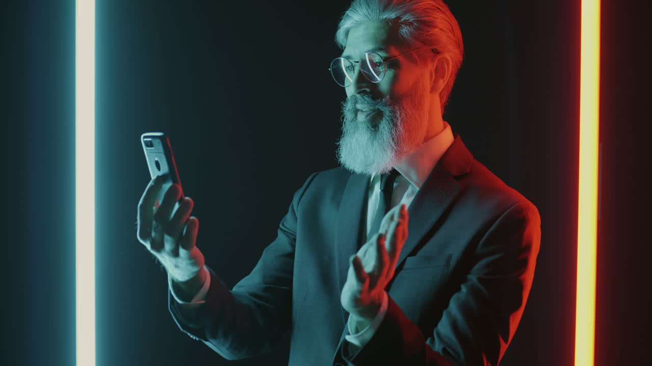 Senior forretningsmann bruker smarttelefon i neonlys
