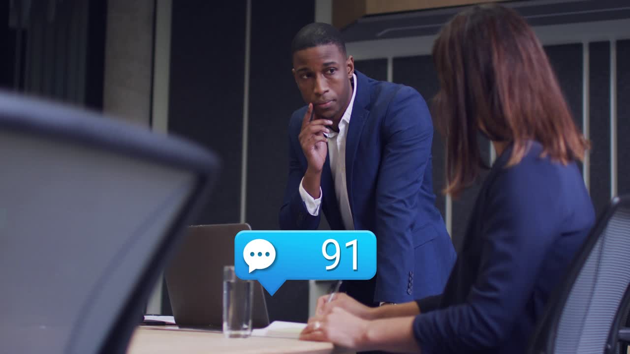 Standing man gesturing in business meeting as chat bubble appearing around him counting messages