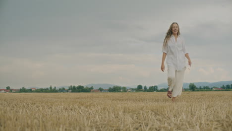 smiling positive woman walking in field